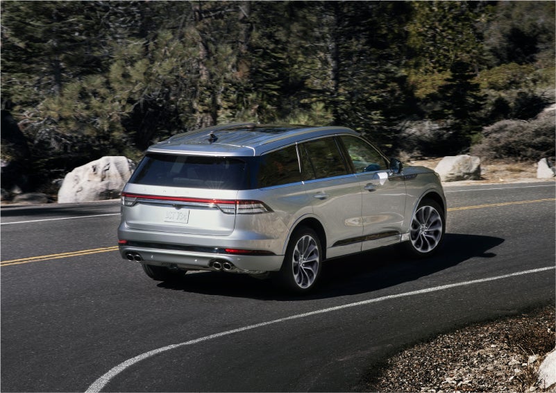 A 2023 Lincoln Aviator® Grand Touring model is shown being driven on a tight turn of a mountain road | Allan Vigil Lincoln, Inc. in Morrow GA