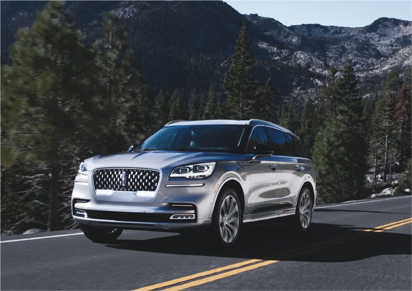 A 2023 Lincoln Aviator® Grand Touring SUV being driven on a winding road to demonstrate the capabilities of all-wheel drive | Allan Vigil Lincoln, Inc. in Morrow GA