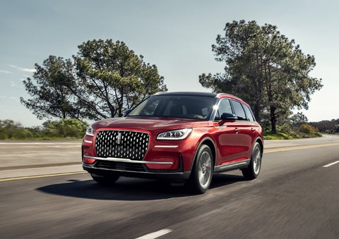A 2024 Lincoln Corsair® SUV is shown being driven on a country road. | Allan Vigil Lincoln, Inc. in Morrow GA