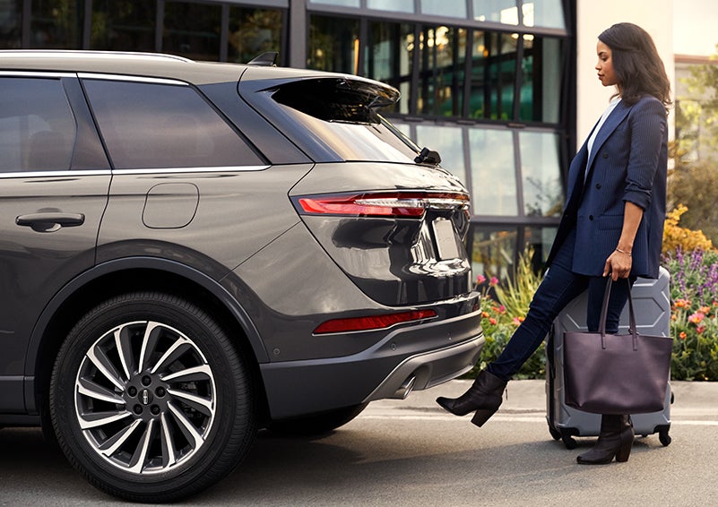 A woman with her hands full uses her foot to activate the available hands-free liftgate. | Allan Vigil Lincoln, Inc. in Morrow GA