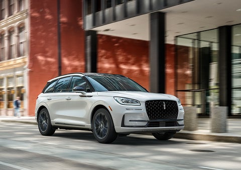 The 2024 Lincoln Corsair® SUV with the Jet Appearance Package and a Pristine White exterior is parked on a city street. | Allan Vigil Lincoln, Inc. in Morrow GA