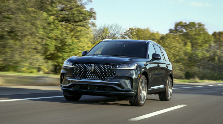 A 2025 Lincoln Black Label Aviator® SUV is being driven down a road lined with trees. | Allan Vigil Lincoln, Inc. in Morrow GA