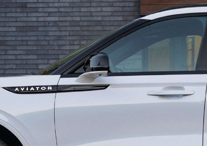 The driver’s side door and fender badging of a white 2026 Lincoln Aviator® SUV are showcased. | Allan Vigil Lincoln, Inc. in Morrow GA