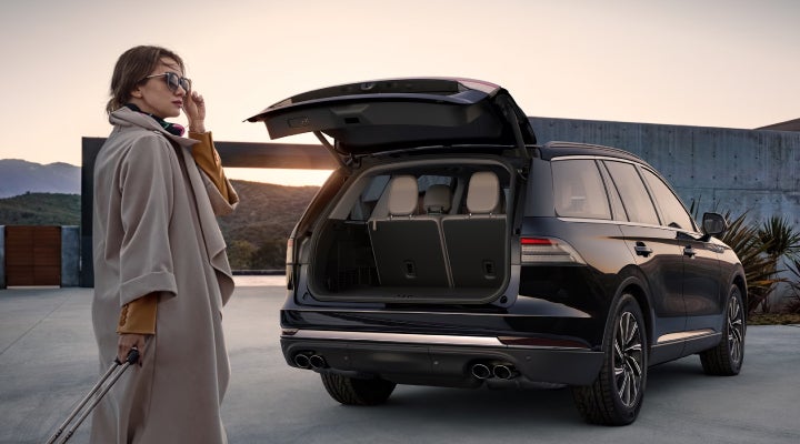 A woman approaches a 2026 Lincoln Aviator® SUV with its rear liftgate open. | Allan Vigil Lincoln, Inc. in Morrow GA