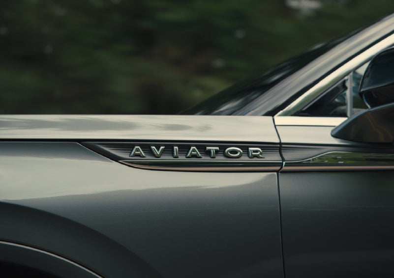 The driver’s side door and fender badging of a gray 2027 Lincoln Aviator® SUV are showcased. | Allan Vigil Lincoln, Inc. in Morrow GA