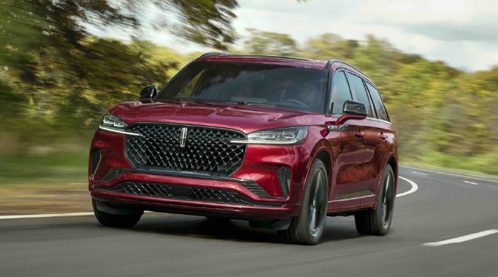A 2027 Lincoln Aviator® SUV is being driven on a country road | Allan Vigil Lincoln, Inc. in Morrow GA